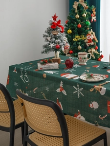 Close-up of green Nordic Christmas tablecloth with Santa and reindeer festive patterns