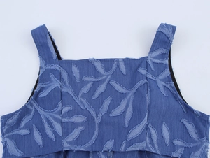 Détail de la robe en jean bleue avec encolure carrée et textures de feuilles effilochées