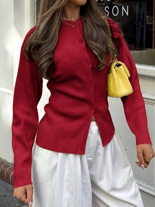 Détail d'un cardigan en maille rouge à manches longues avec boutons sur un fond de rue urbain