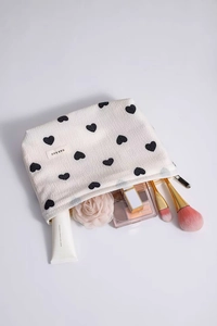 Close-up of white heart print makeup bag showing internal storage for cosmetics