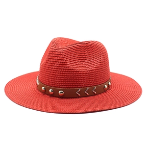 Detail of red fedora straw hat with brown band featuring silver rivets and metal accents