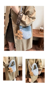 Detail of blue faux shearling bucket bag featuring a cute brown plush bear charm
