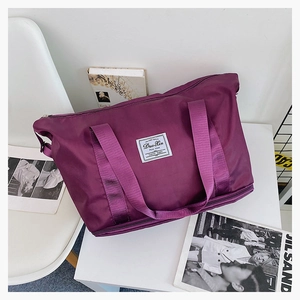 Detail of purple travel bag featuring water-resistant fabric and expandable bottom layer