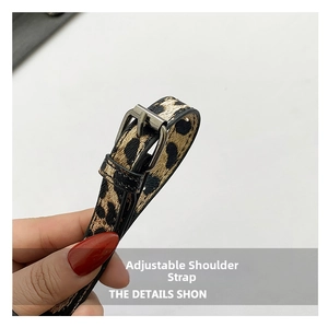 Macro view of leopard print adjustable leather shoulder strap with silver metal buckle