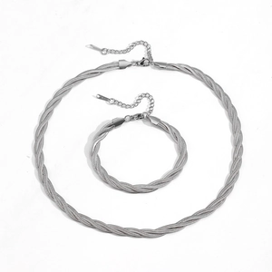 Vista dettagliata di un set di collana e braccialetto a tre fili intrecciati argento