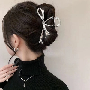Silver metallic butterfly hair claw clip shown on model's hair with elegant styling