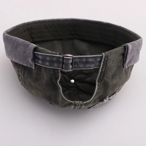 Detail of adjustable metal buckle and vintage washed cotton texture on docker cap