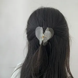 Elegant transparent heart-shaped hair claw clip for women shown on long hair