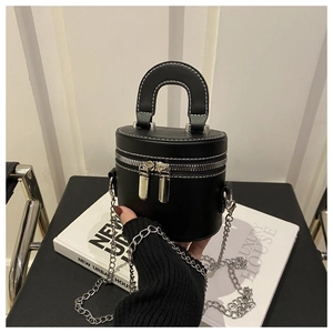 Détail du sac cylindre en cuir PU noir avec surpiqûres blanches et chaîne argentée