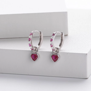 Macro shot of S925 sterling silver heart earrings with red gemstones and white zircons