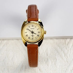 Elegant women's quartz watch with gold oval case, champagne dial and brown leather strap