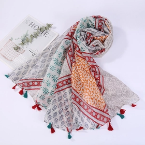 Detail shot of cotton linen beach scarf featuring ethnic print and red fringe tassels