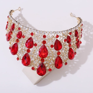 Detailed macro view of golden baroque crown with red crystals and shimmering rhinestones