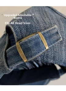 Detail of adjustable bronze metal buckle on the back of blue denim newsboy cap