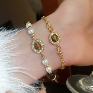 Détail de bracelets Maillard avec perles, pierres œil de tigre et chaînes dorées