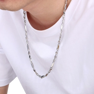 Gros plan d'un collier en acier titane argenté à maillons torsadés sur un mannequin
