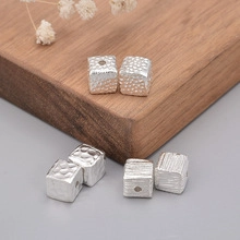 Macro view of square S925 sterling silver spacer beads with unique hammered texture