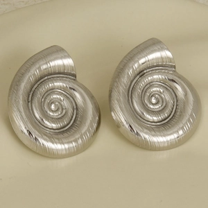 Macro shot of silver stainless steel nautilus shell earrings with brushed metal texture