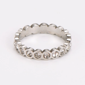 Macro shot of silver stainless steel eternity ring featuring polished bezel-set cubic zirconia