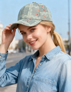Detail of light grey-green baseball cap with crackle pattern and red star print on model