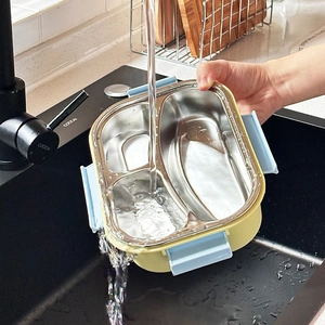 Waterproof stainless steel lunch box with 3 compartments being rinsed in a kitchen sink