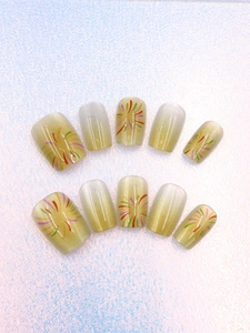 Dettaglio di unghie finte champagne cat eye con design nail art a fuochi d'artificio