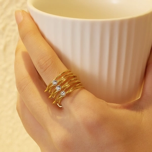 Macro detail of 18k gold plated multi-layer pearl ring with three crystals on finger