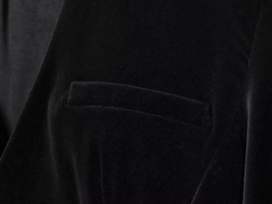 Macro detail of the velvet fabric texture and sleek welt pocket on this black romper
