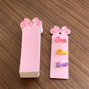 Pink hair clip display card with polka dot bow detail and assorted floral accessories