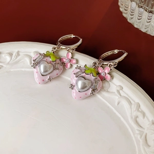 Nahaufnahme von rosa Erdbeeren-Ohrringen mit Herzperlen und Blumenanhängern