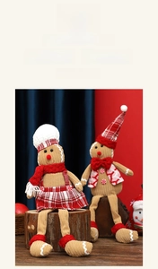 Close-up of plush gingerbread man and woman dolls in Christmas outfits on wood