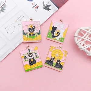 Detailed macro view of four black cat tarot enamel charms on a soft pink background