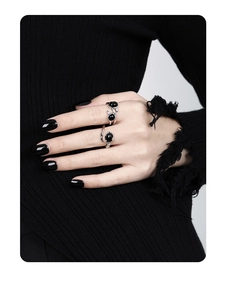 Close-up of three irregular S925 silver rings with black onyx insets on fingers