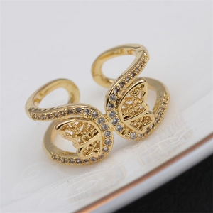 Gold butterfly open ring with white cubic zirconia stones on white ceramic plate
