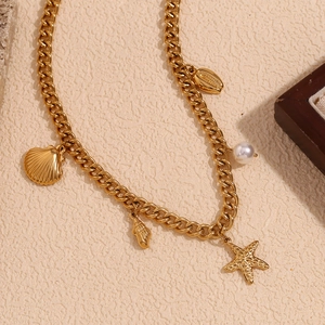 Detailed view of 18K gold plated shell, starfish and pearl pendants on a chunky chain