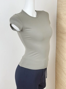 Detail view of olive green athletic tight-fit T-shirt showing high-stretch fabric texture