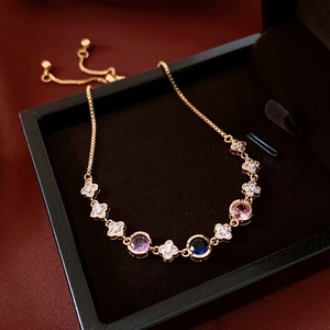Detail of 18k gold plated clover bracelet featuring colorful gemstones and pull adjustment