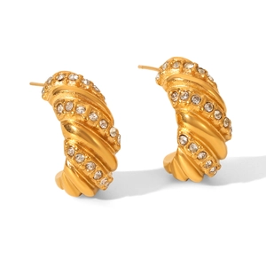 Detail shot of golden twisted croissant hoop earrings with sparkling rhinestones