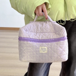 Dettaglio della borsa da toilette trapuntata a quadretti viola con manico morbido