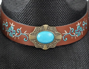 Dettaglio cappello da cowboy nero con gemma turchese e ricamo floreale su cinturino