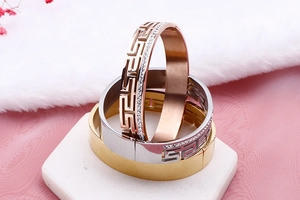 Detailed view of stainless steel bracelets with Greek key pattern and side diamond inlay