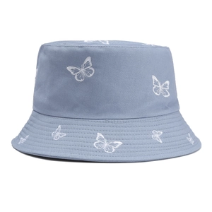 Dettaglio del cappello a secchiello azzurro con raffinati ricami a forma di farfalla