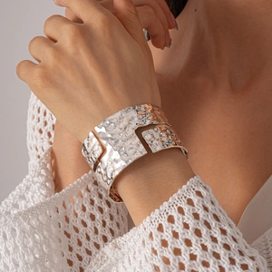 Macro shot of silver wide cuff bracelet featuring hammered texture and hollow geometry