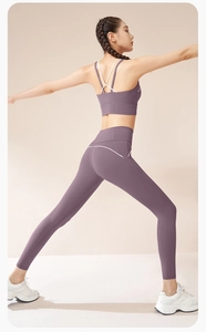 Dettaglio dei pantaloni yoga color malva a vita alta con strisce bianche e reggiseno