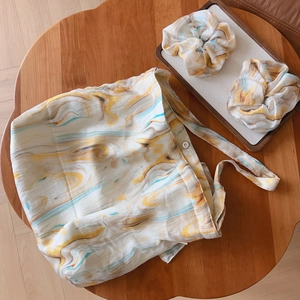 Detail of artistic marble pattern tote bag and matching scrunchies on wooden tray