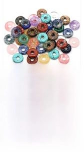 Macro display of diverse natural crystal donut pendants with English gemstone labels