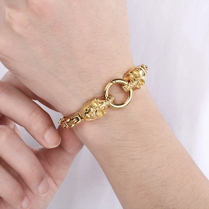 Nahaufnahme des goldenen Punk-Totenkopf-Armbands mit Gliedern an einem Handgelenk