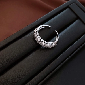 Detailed close-up of open ring with hollow design and pave-set white zircons
