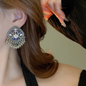 Detailed shot of ethnic style geometric earrings with blue enamel and silver tassel fringe