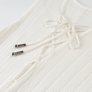 Macro view of ribbed knit fabric detail and lace-up front with metallic accents